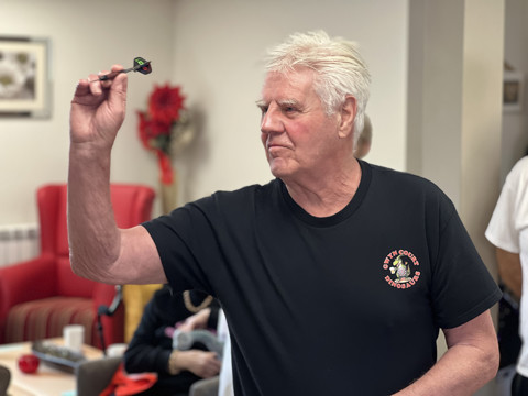 Haven resident aiming a dart at the dartboard