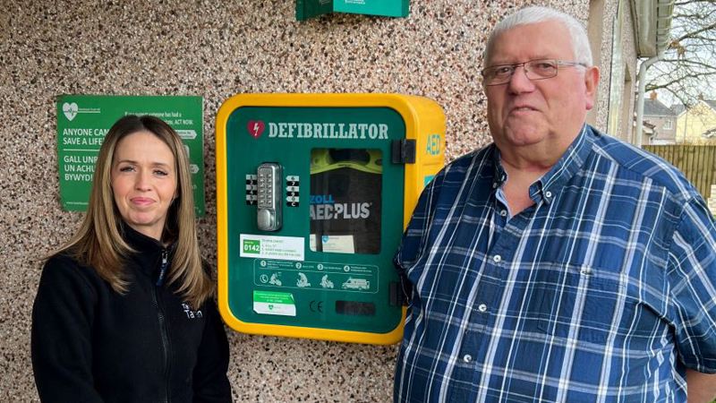 Tai Tarian tenant and staff member by the defibrillator at Llys Nant Fer in Gwaun Cae Gurwen