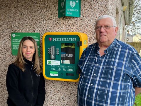 Tai Tarian tenant and staff member by the defibrillator at Llys Nant Fer in Gwaun Cae Gurwen