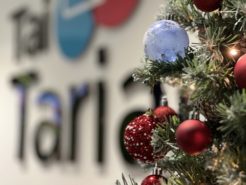 Christmas tree in front of a Tai Tarian sign