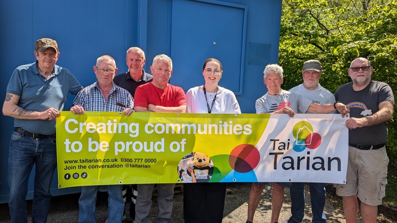 Tai Tarian staff and Men's Shed attendees holding a Tai Tarian banner