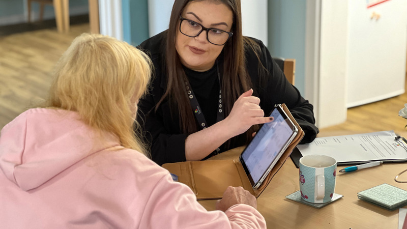 Hannah helping a tenant get online