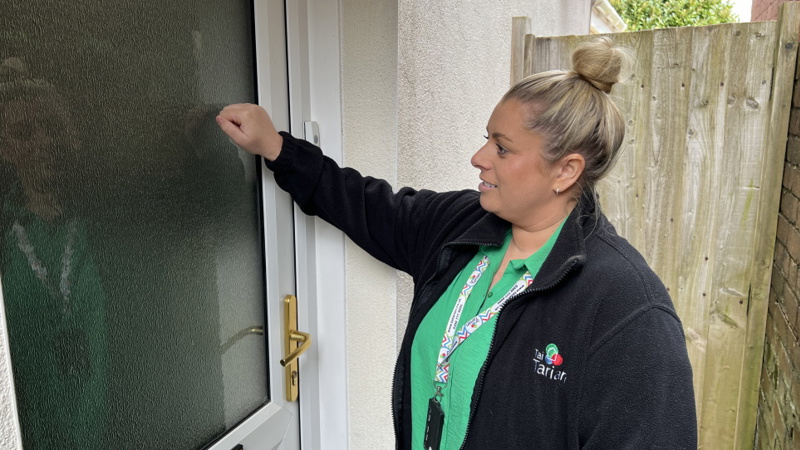 A genuine Tai Tarian staff member, wearing her ID badge, knocking on a tenant's door