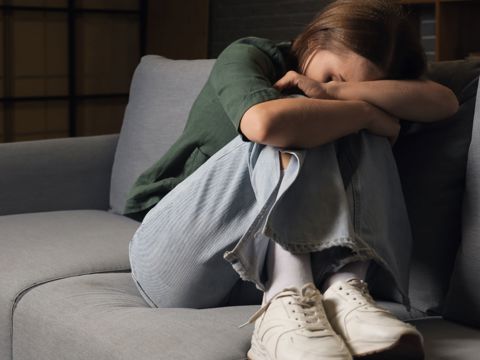 A person upset on a sofa